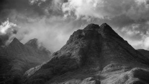 A black and white photograph of the mountain Sgurr Na Stri and ominous weather approaching over the Cuillin ridges. Taken from Elgol on the Isle of Skye.